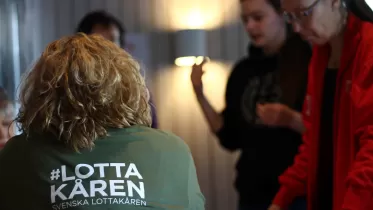 Kvinna med grön tröja märkt #Lottakåren