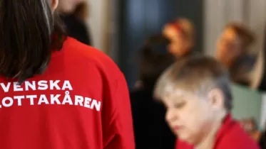 Kvinna med röd tröja märkt Svenska Lottakåren