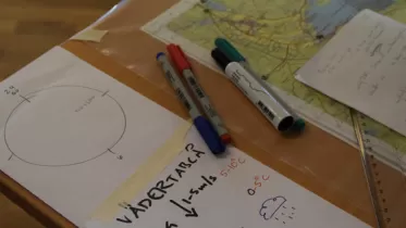 Pennor och karta organiserat på ett bord